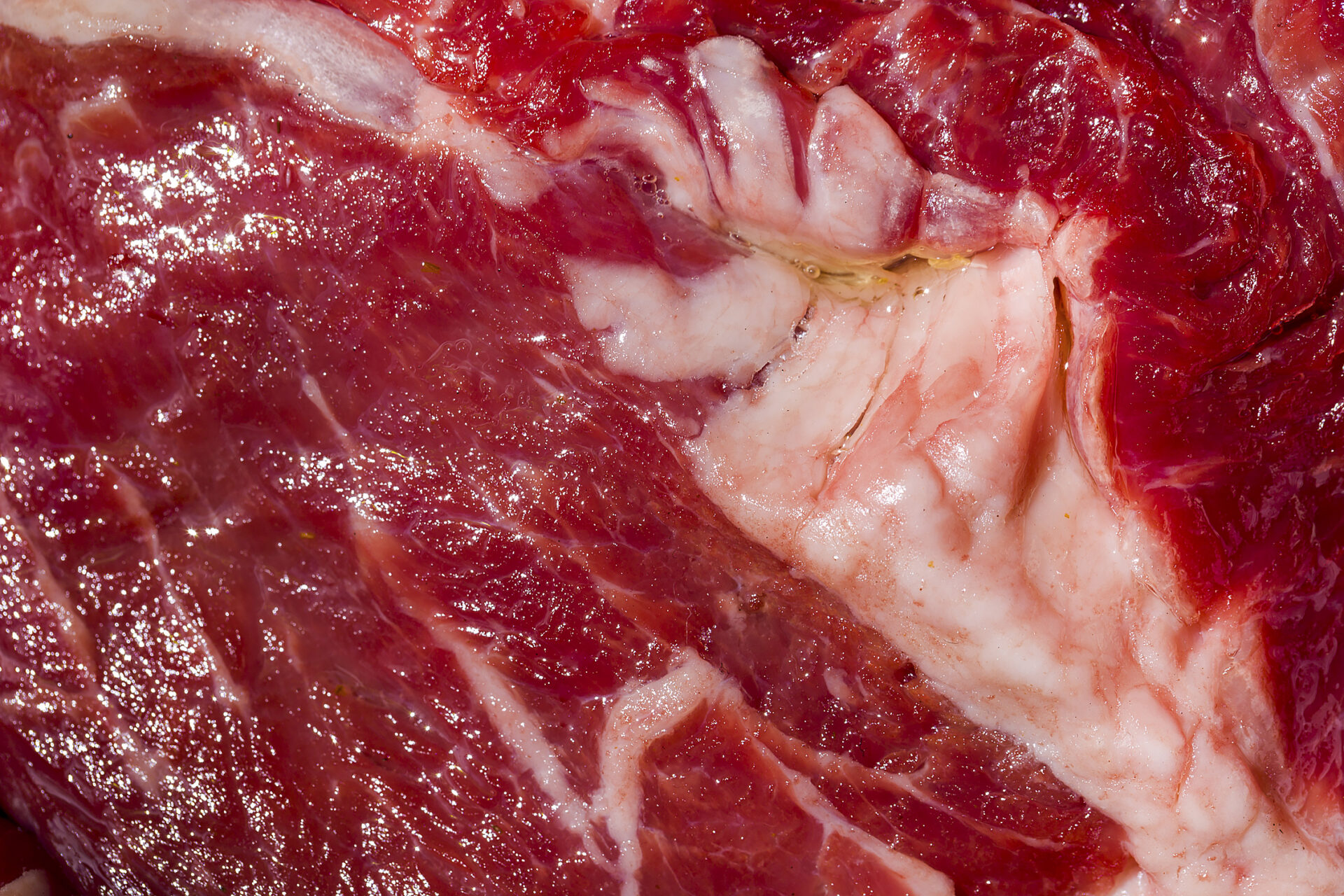 Raw beef meat with salt and peppercorns, close-up. Horizontal orientation